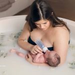 new mother bottle feeding her newborn in a milk bath